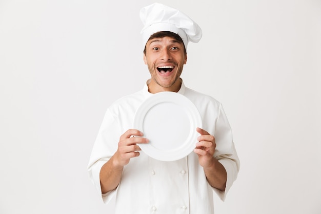 Uśmiechnięty kucharz prezentujący danie